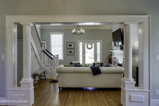 living room with crown molding, hardwood / wood-style floors, and ornate columns