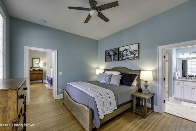 bedroom featuring connected bathroom, light hardwood / wood-style flooring, sink, and ceiling fan