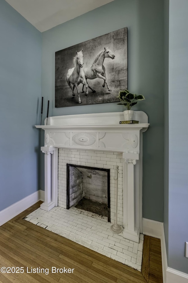 interior details featuring a fireplace and wood-type flooring