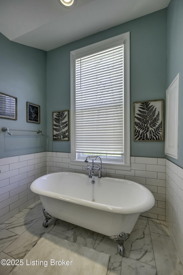 bathroom with a bathing tub and tile walls