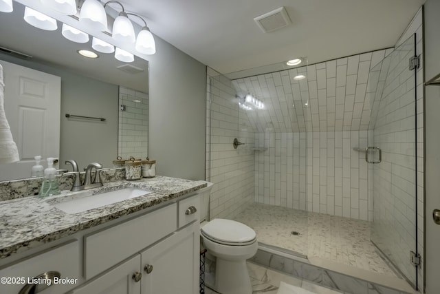 bathroom featuring vanity, an enclosed shower, and toilet