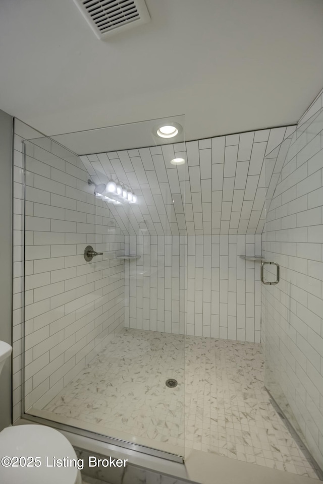 bathroom featuring walk in shower and toilet