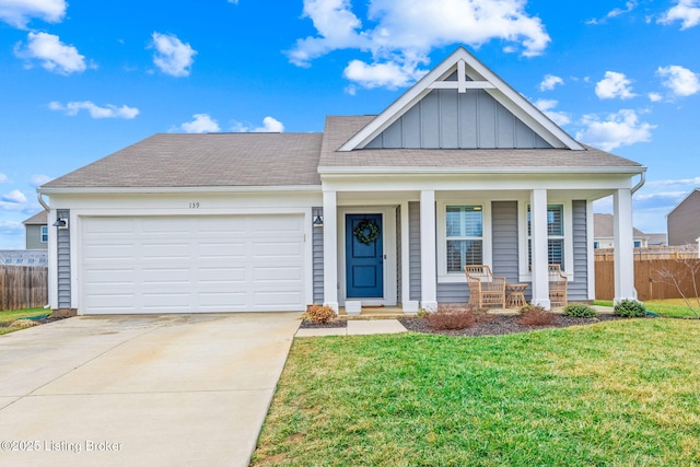 view of front of house featuring a garage, a front yard, and covered porch