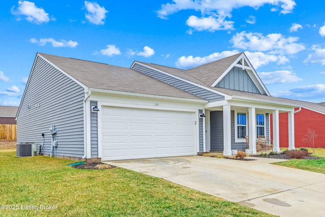 view of front of home featuring a garage, a front yard, central air condition unit, and covered porch