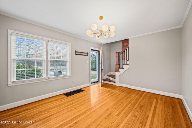 foyer entrance featuring a notable chandelier, ornamental molding, and light wood-type flooring