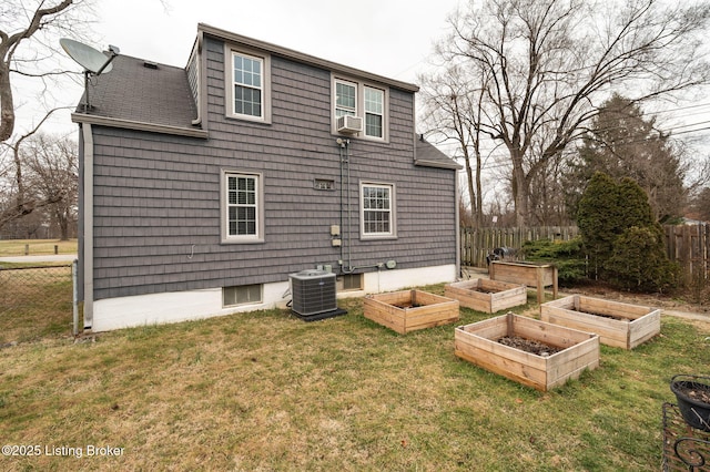 rear view of property featuring central AC, a yard, and cooling unit