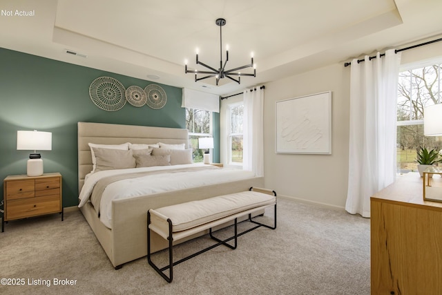 carpeted bedroom featuring a chandelier, a raised ceiling, and multiple windows