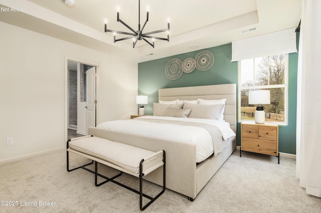 carpeted bedroom with a notable chandelier and a raised ceiling