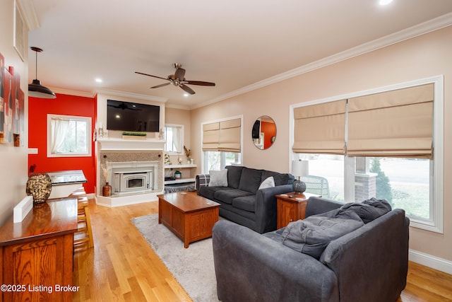 living room with ornamental molding, light hardwood / wood-style floors, and ceiling fan