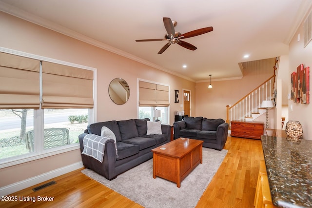 living room featuring crown molding, light hardwood / wood-style floors, and ceiling fan