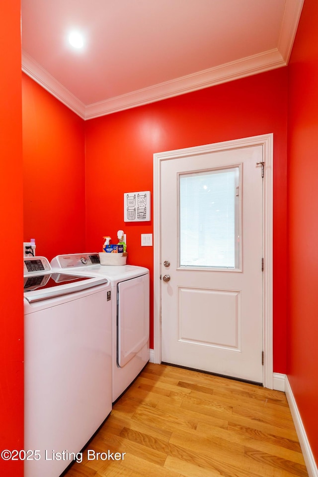 clothes washing area with ornamental molding, separate washer and dryer, and light wood-type flooring