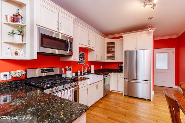 kitchen with sink, ornamental molding, stainless steel appliances, and white cabinets