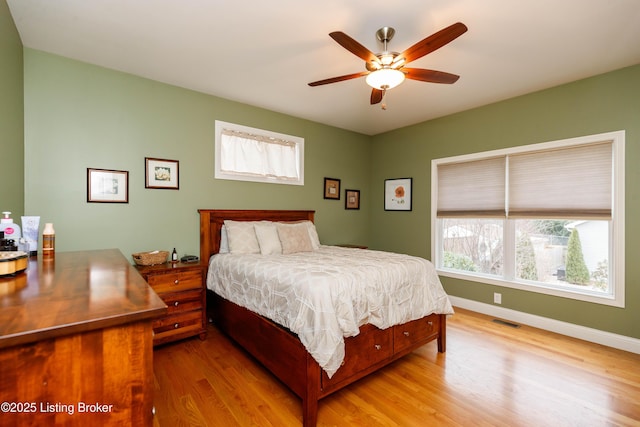 bedroom with multiple windows, ceiling fan, and light hardwood / wood-style floors