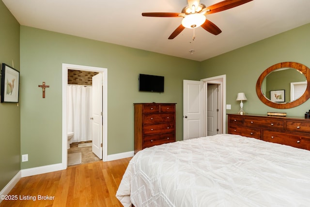 bedroom with ensuite bath, light hardwood / wood-style floors, and ceiling fan