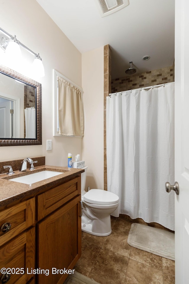 bathroom featuring vanity, toilet, and walk in shower