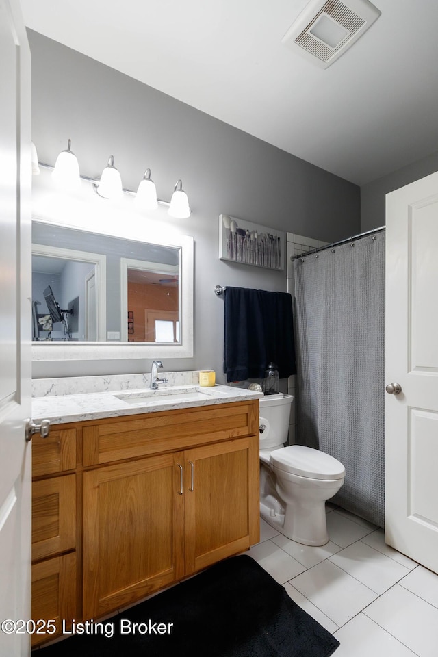 bathroom featuring vanity, tile patterned floors, and toilet