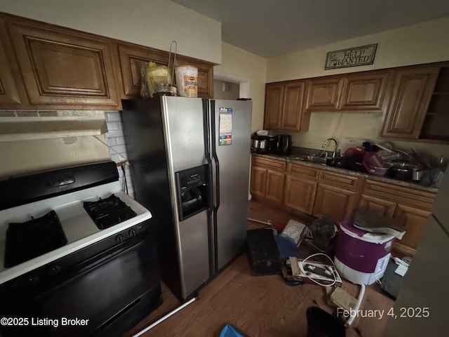 kitchen featuring stainless steel fridge, sink, and gas stove