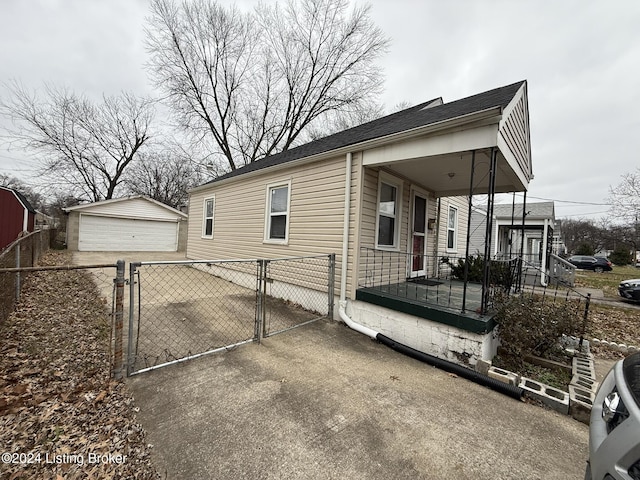 view of property exterior with a garage, an outdoor structure, and a porch