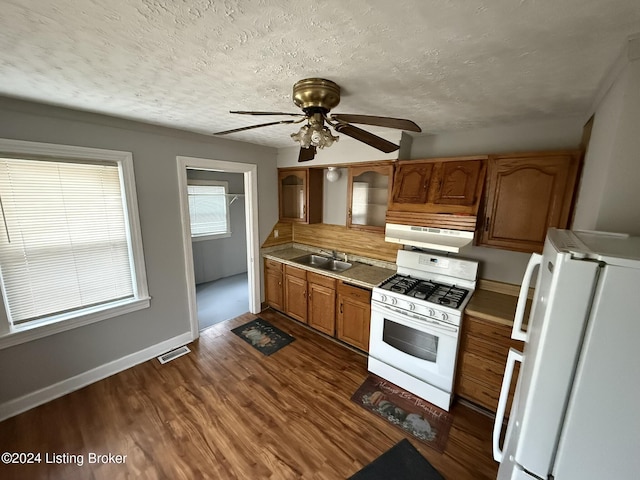 kitchen featuring sink, white appliances, ceiling fan, a textured ceiling, and dark hardwood / wood-style flooring