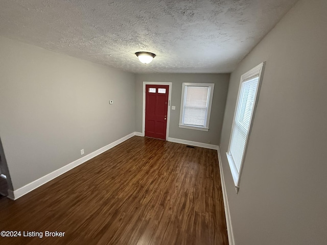 entryway with dark hardwood / wood-style flooring and a textured ceiling