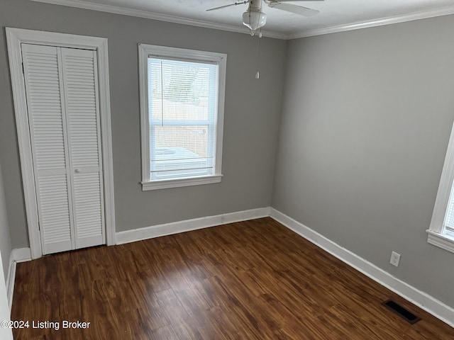 unfurnished bedroom featuring dark hardwood / wood-style flooring, ornamental molding, a closet, and ceiling fan