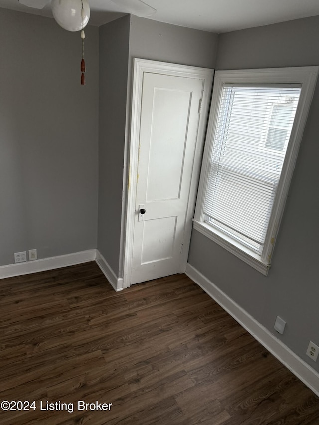 spare room with plenty of natural light and dark hardwood / wood-style floors