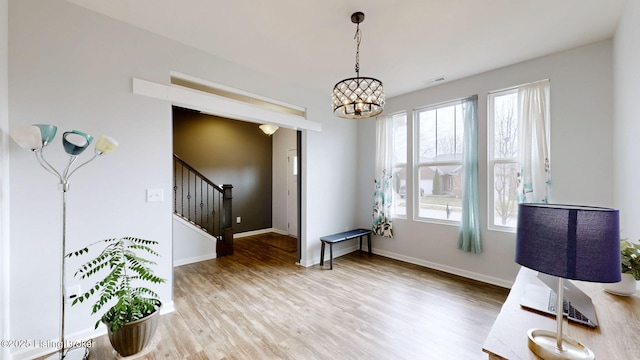 interior space with wood-type flooring and an inviting chandelier