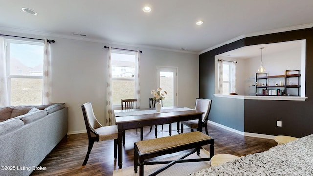 dining area featuring crown molding, dark wood-type flooring, and a wealth of natural light