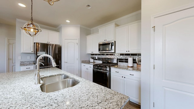 kitchen with light stone counters, sink, white cabinets, and appliances with stainless steel finishes