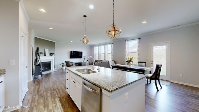 kitchen with white cabinetry, dishwasher, sink, hanging light fixtures, and a kitchen island with sink