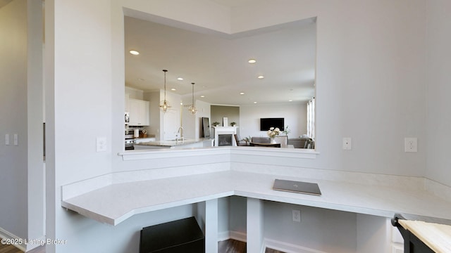 kitchen with white cabinetry, a breakfast bar, sink, and hanging light fixtures