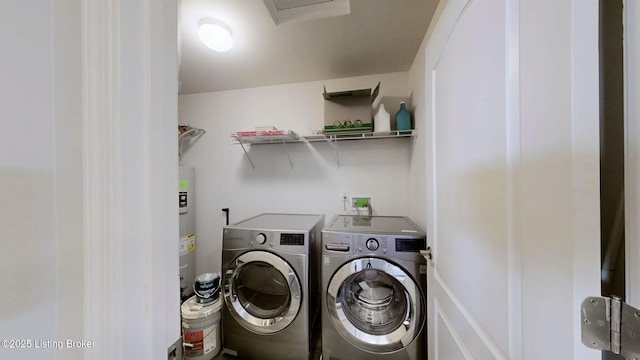 washroom with electric water heater and washer and dryer