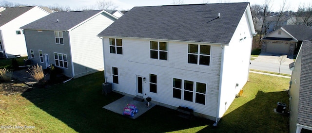 back of property with central AC, a garage, and a lawn