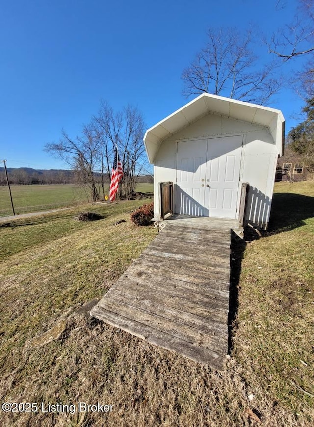 exterior space featuring a storage shed, a yard, and a rural view