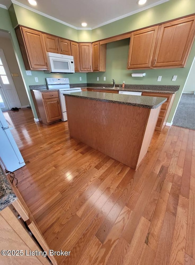 kitchen featuring crown molding, white appliances, a kitchen island, and light hardwood / wood-style flooring