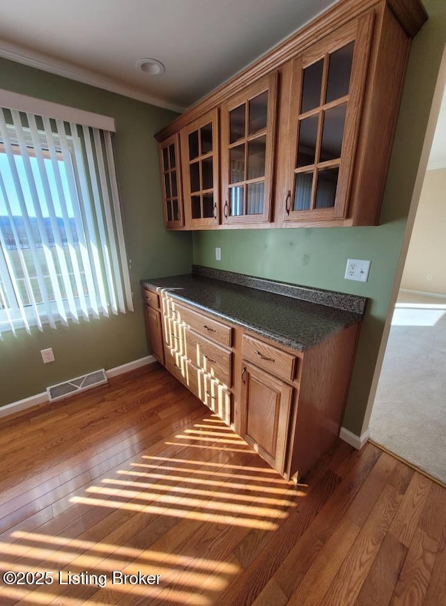 kitchen with dark wood-type flooring and ornamental molding