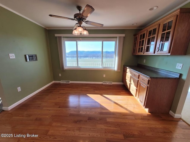 kitchen with ornamental molding, dark wood-type flooring, and ceiling fan