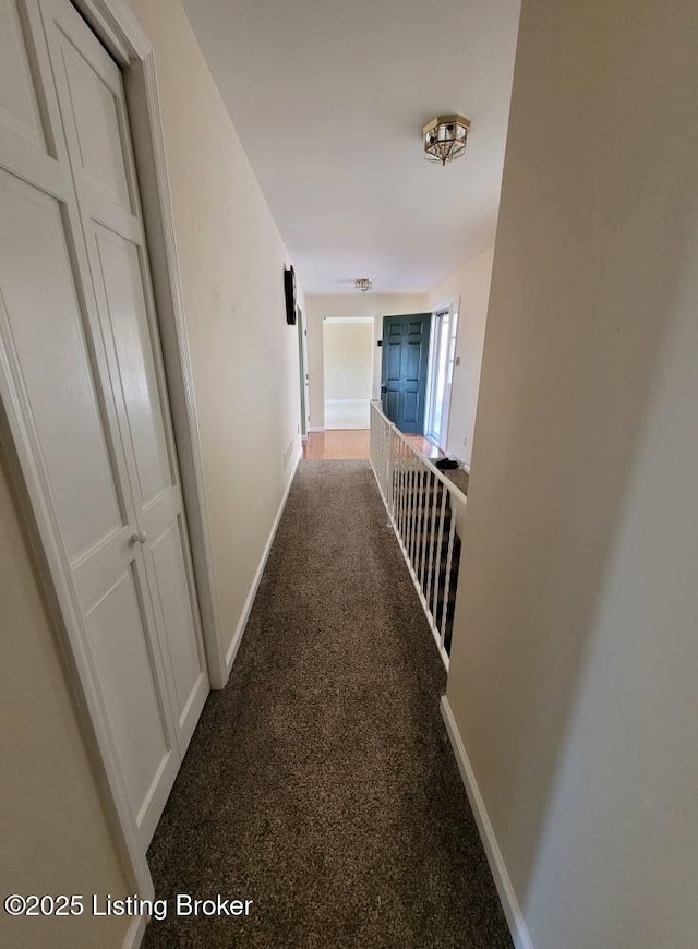 hall featuring dark colored carpet