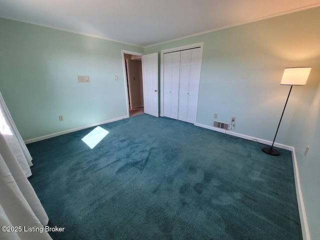 unfurnished bedroom with crown molding, dark carpet, and a closet