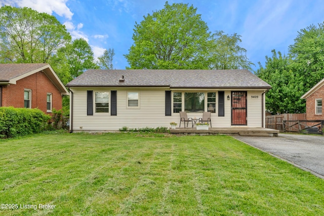 ranch-style home with a porch, a front yard, aphalt driveway, and fence