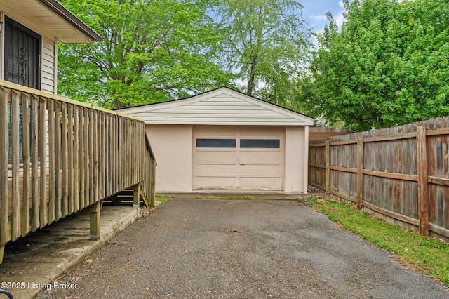 detached garage with fence and aphalt driveway