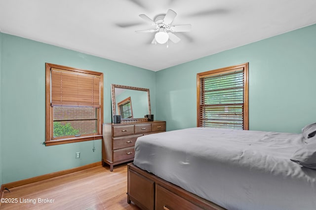 bedroom featuring ceiling fan, light wood-style flooring, and baseboards