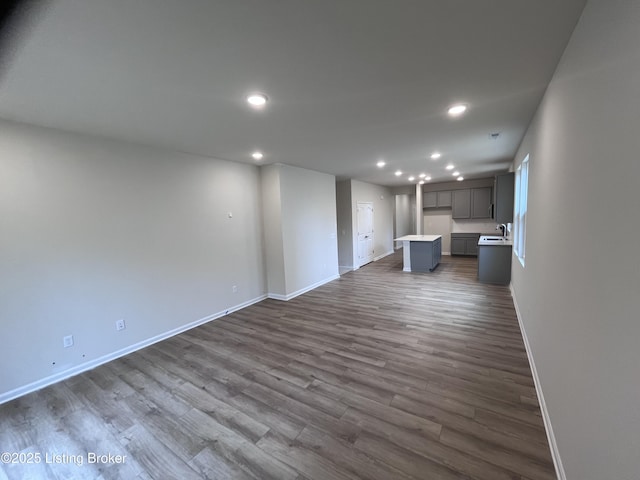 unfurnished living room with sink and dark wood-type flooring