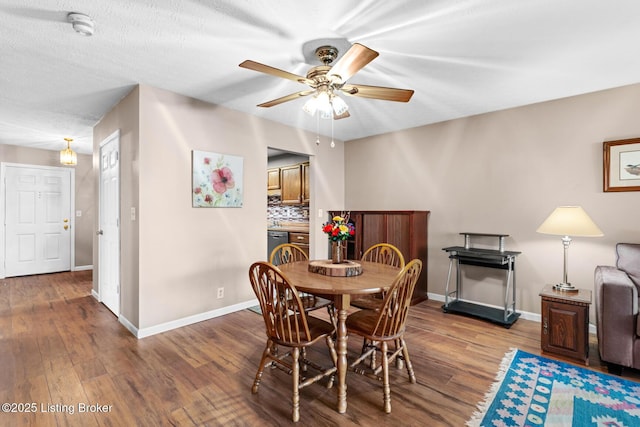 dining room with a textured ceiling, wood-type flooring, and ceiling fan