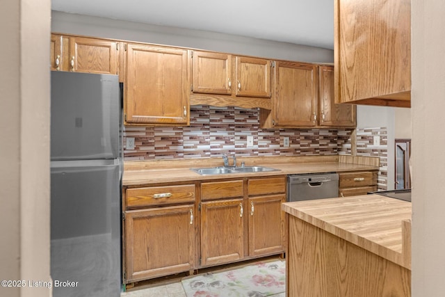 kitchen featuring stainless steel appliances, butcher block counters, sink, and backsplash