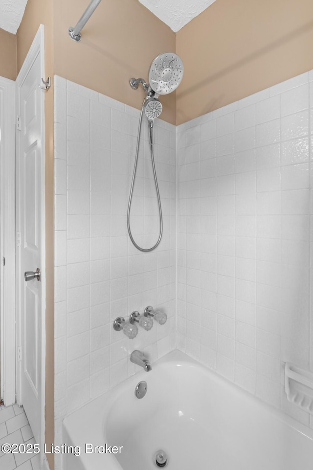 bathroom with tiled shower / bath, tile patterned flooring, and a textured ceiling