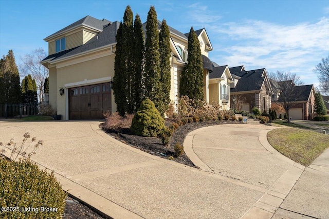 view of front of house featuring a residential view, driveway, and fence