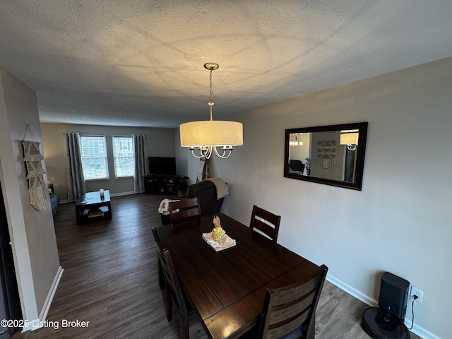 dining space with dark hardwood / wood-style floors and a textured ceiling