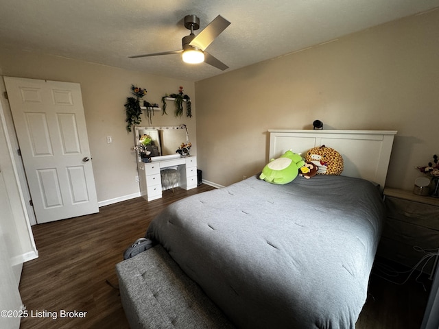 bedroom featuring ceiling fan, dark hardwood / wood-style floors, and a textured ceiling