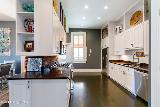 kitchen with high end appliances, sink, and white cabinets